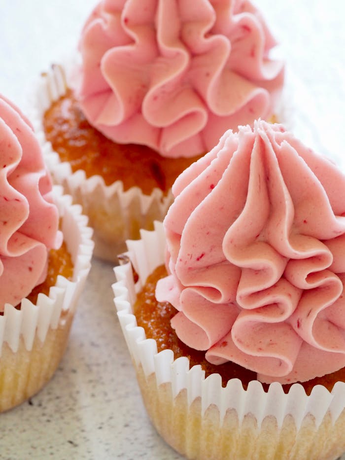 Tasty cupcakes with pink frosting, perfect for a sweet treat or dessert celebration.